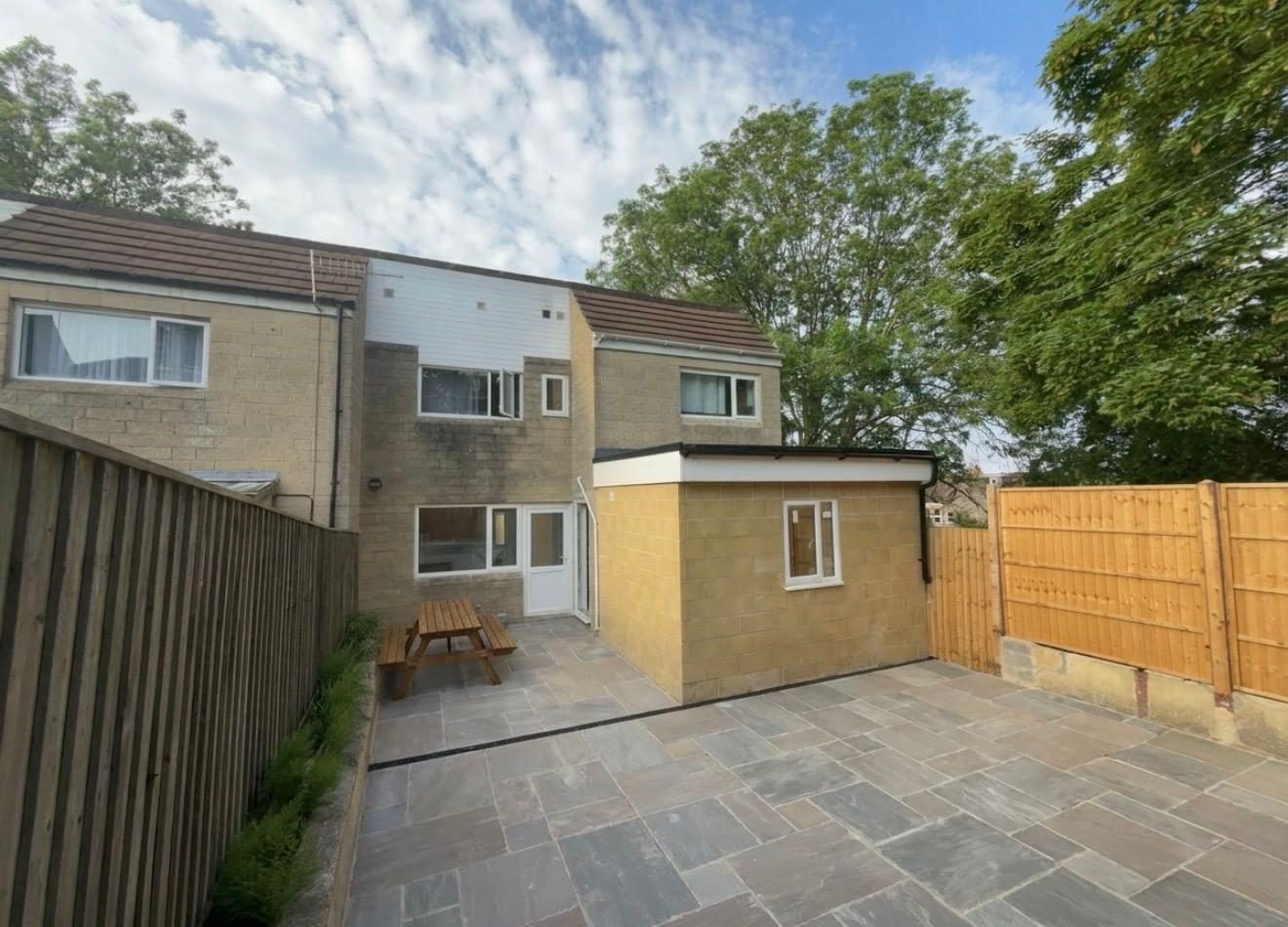 Completed single-storey rear extension in Bath stone with new patio