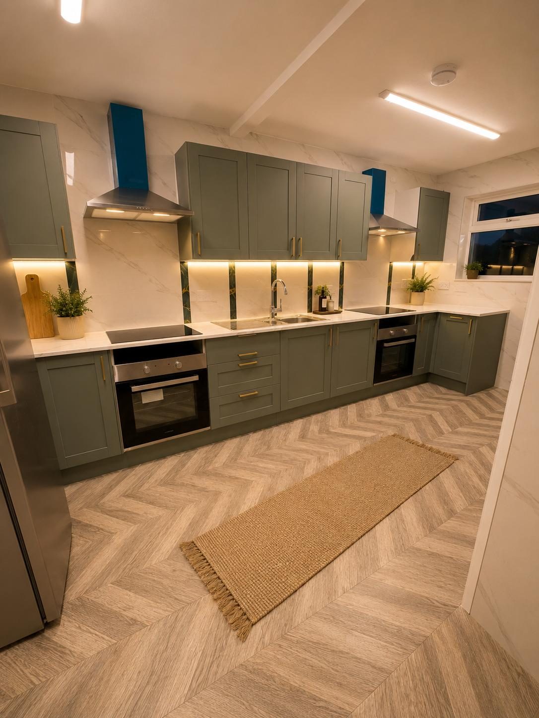Finished sage-green shaker kitchen with herringbone flooring